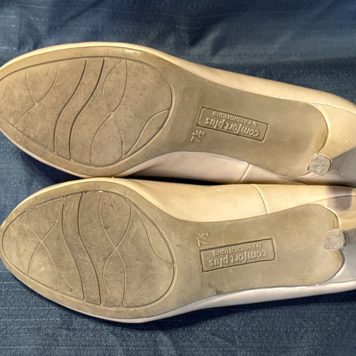 Bottom view of Comfort Plus by Predictions pumps showing worn soles, heel tips, and size 7.5 markings.
