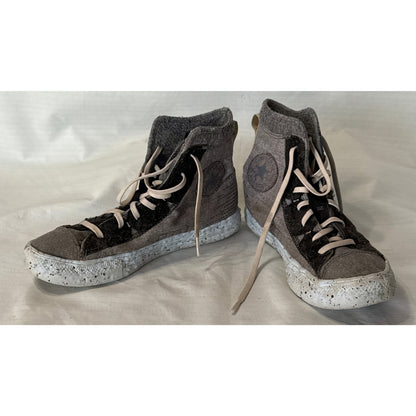 Angled view of Converse Chuck Taylor All Star Crater gray and black high-top sneakers with speckled soles and ankle patches.