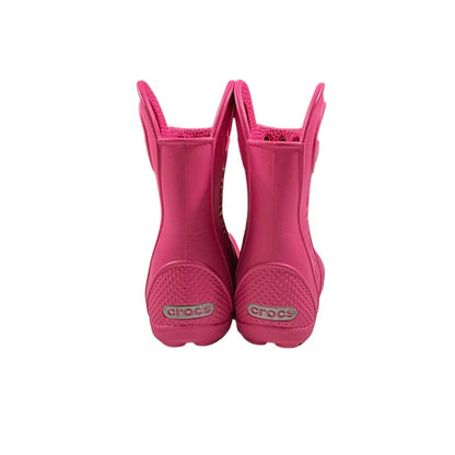 Back view of pink Crocs toddler rain boots with pull handles.