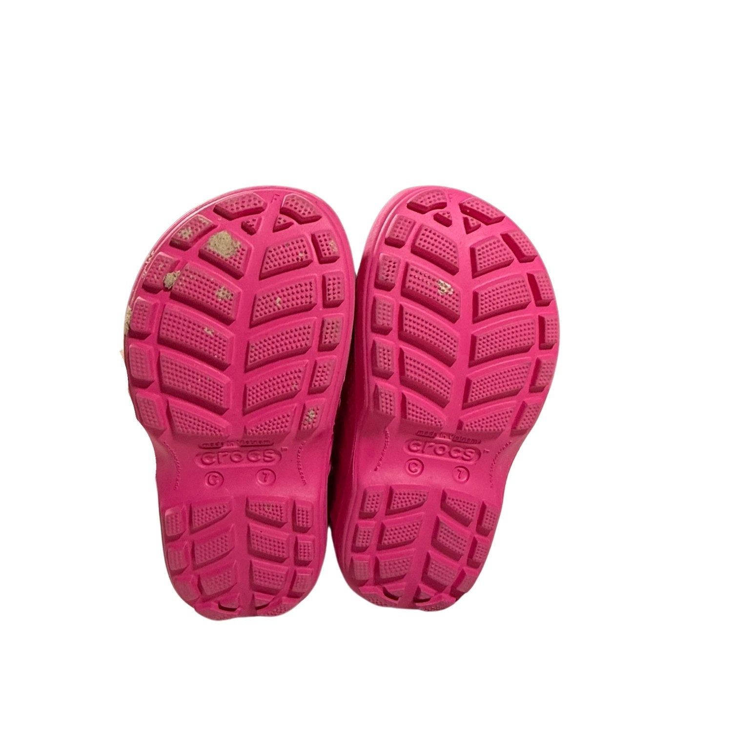 Outsoles of pink Crocs toddler rain boots showing tread.