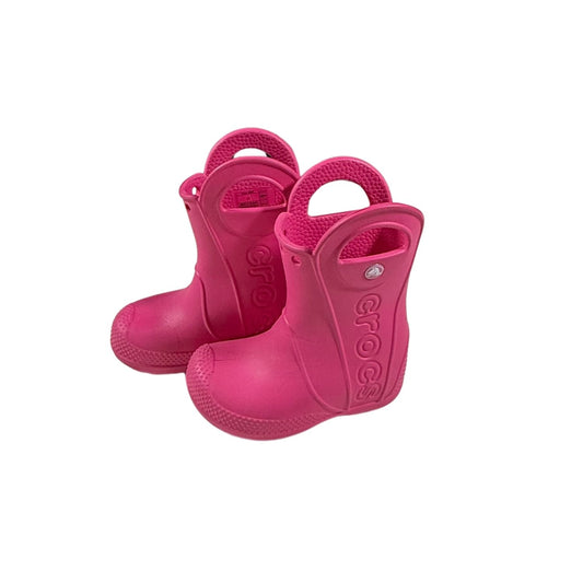 Side view of pink Crocs waterproof rain boots for toddlers.