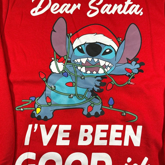 Close-up of Stitch wearing a Santa hat tangled in decorative lights on red Christmas sweatshirt