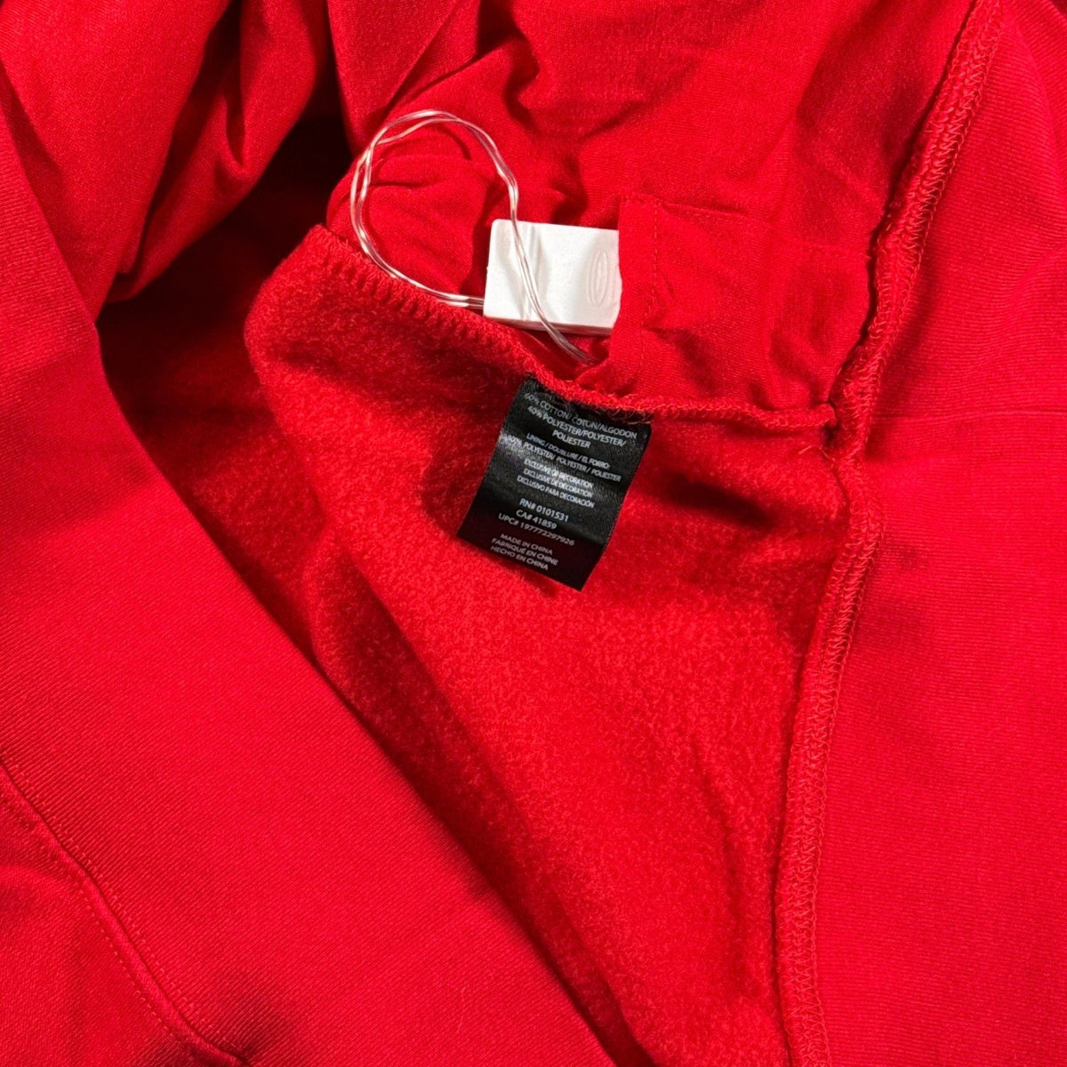 Interior battery pack, storage pocket, lining, and material label inside Stitch Christmas sweatshirt