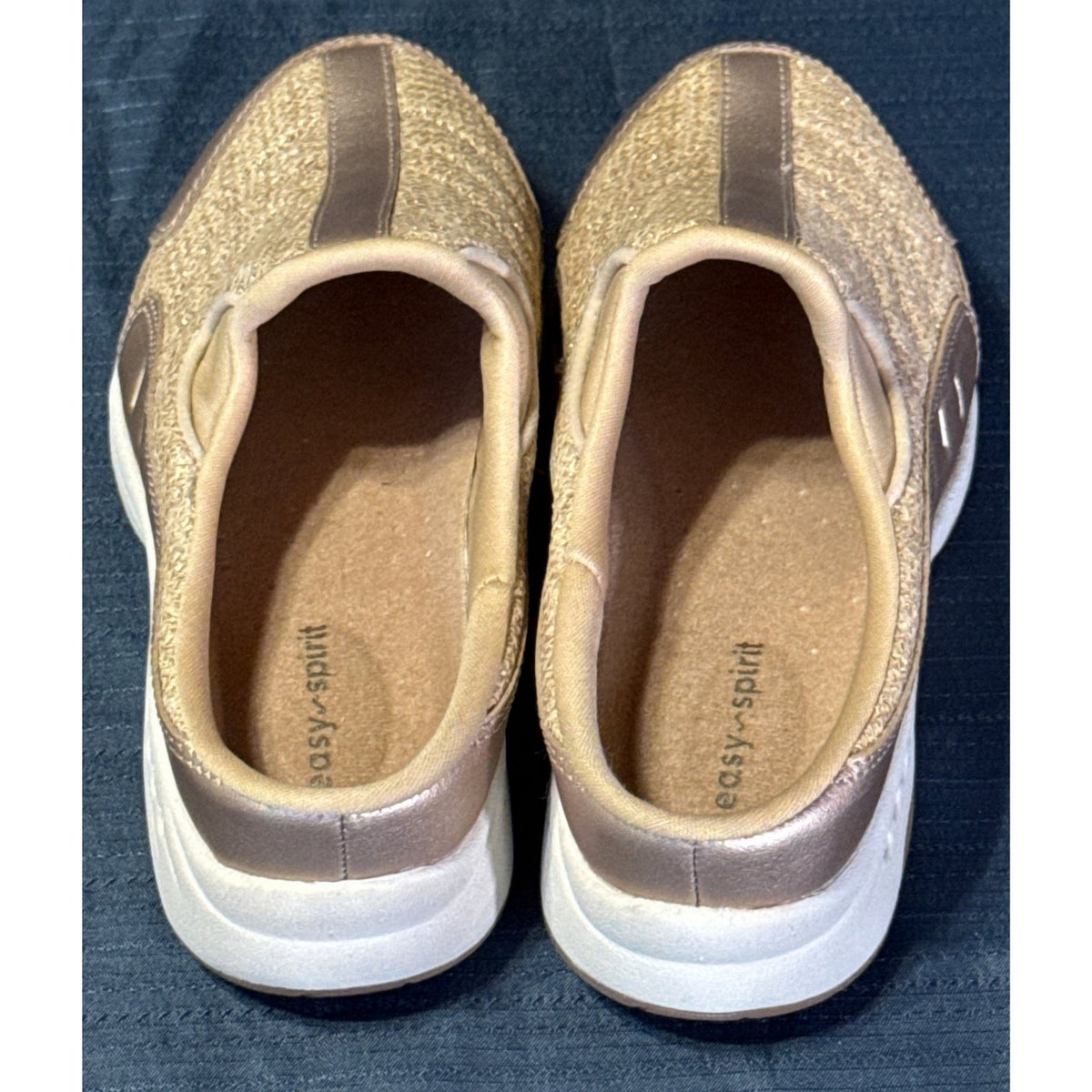 Interior view of Easy Spirit mule sneakers showing tan insoles, branding, and padded openings.
