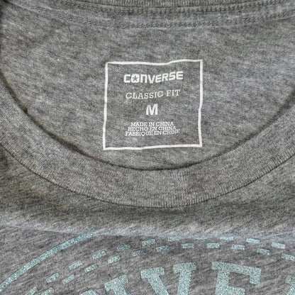 Turquoise glitter Converse logo close up on gray shirt