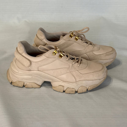 Side view of blush beige JustFab Ximena chunky sneakers showing mixed-texture uppers, gold-tone lace hooks, and sculpted soles.