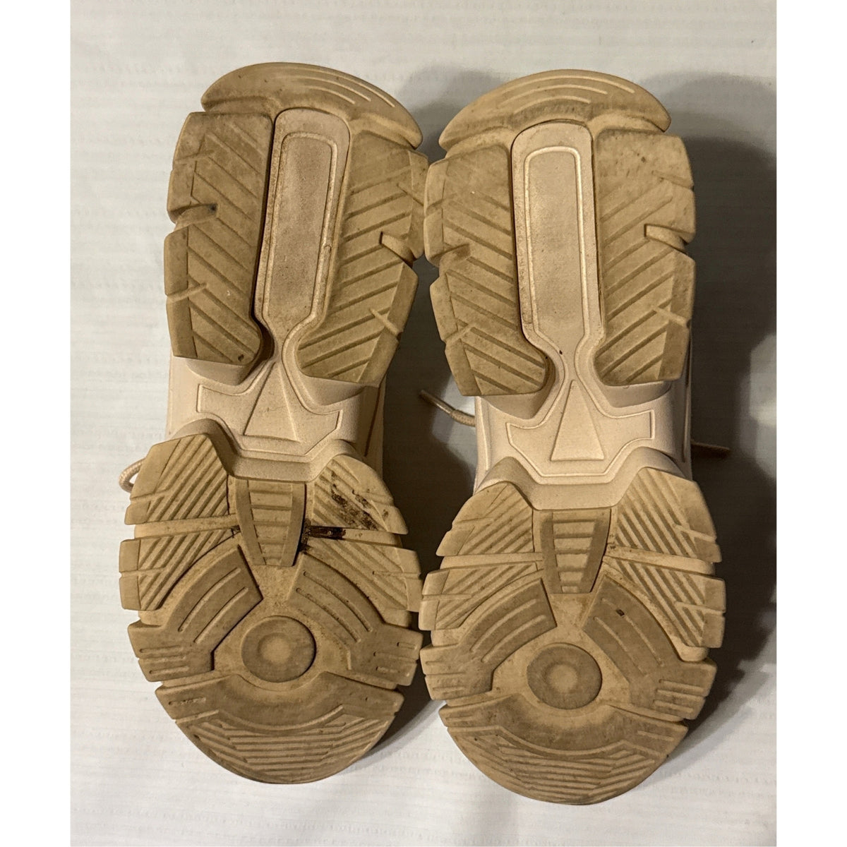 Bottom view of JustFab Ximena chunky sneakers showing beige lug-patterned outsoles and signs of wear.