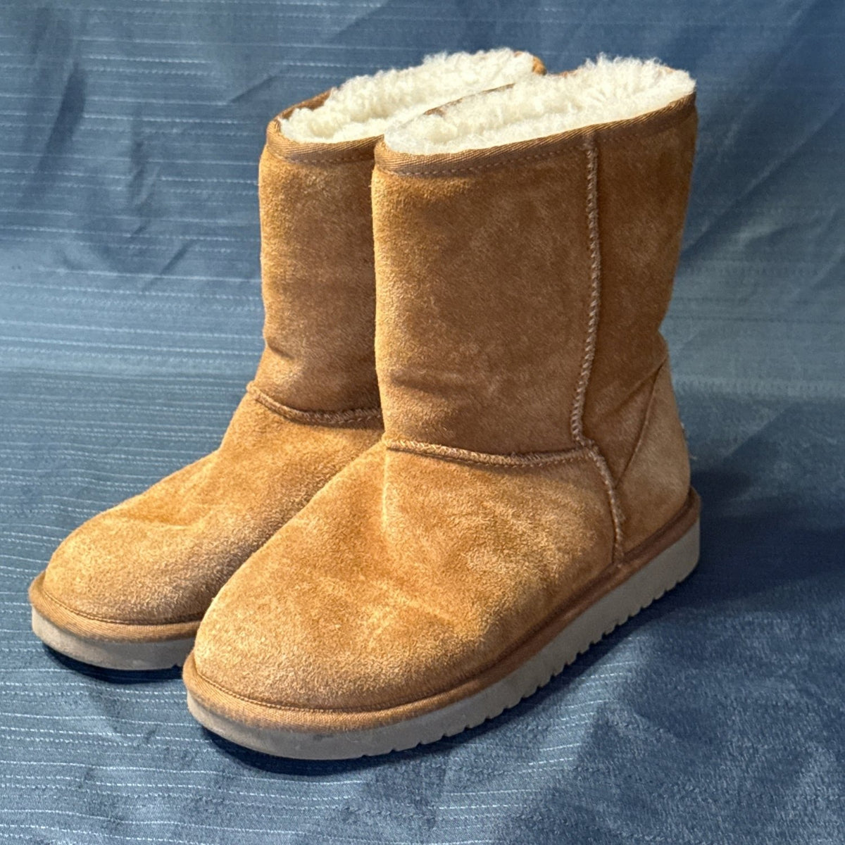 Angled view of Koolaburra by UGG chestnut boots showing suede texture and normal surface wear.