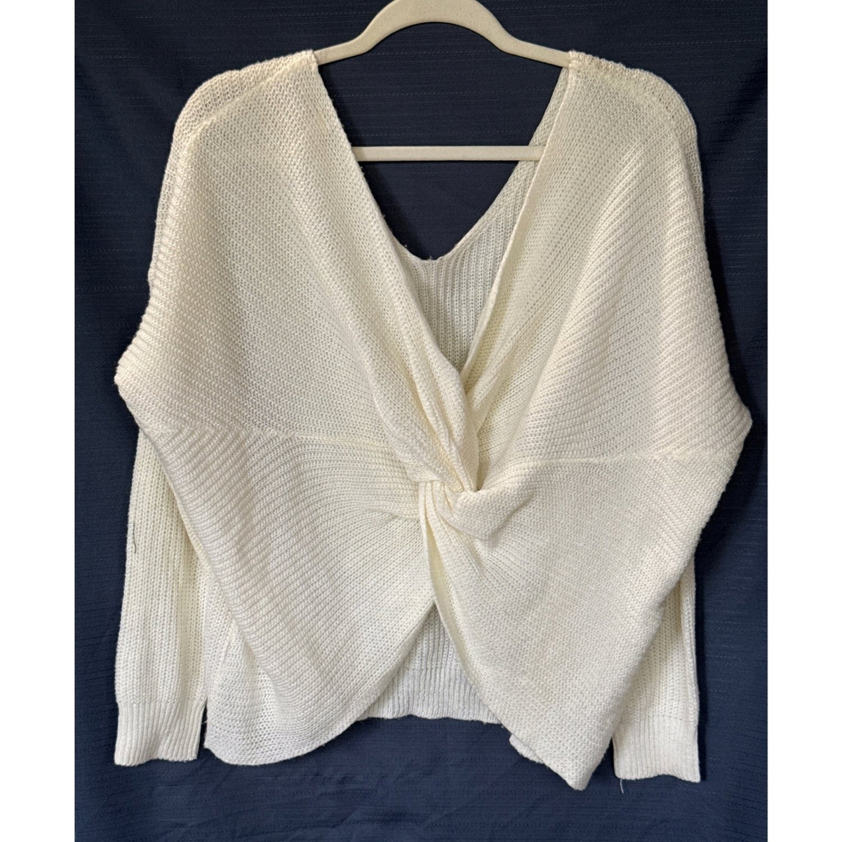 Front view of an ivory Lara Fashion sweater with a draped twist front, V-neckline, and long sleeves.
