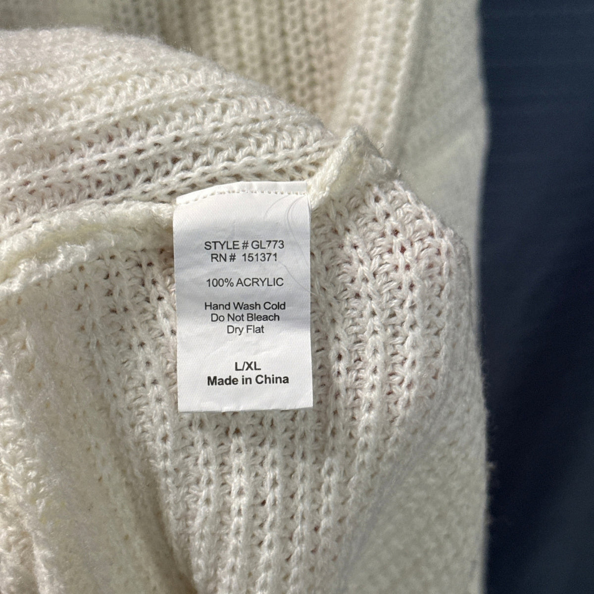 Lara Fashion sweater care label showing 100% acrylic, size L/XL, and hand wash cold and dry flat instructions.