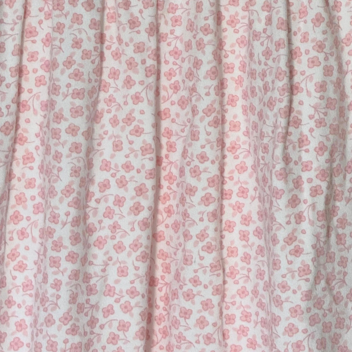 Close-up of delicate pink floral print on Little Me baby girls footed sleeper.