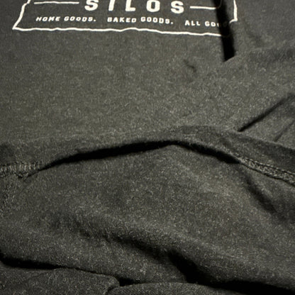 Close-up of loose stitching at another section of the T-shirt’s bottom hem.