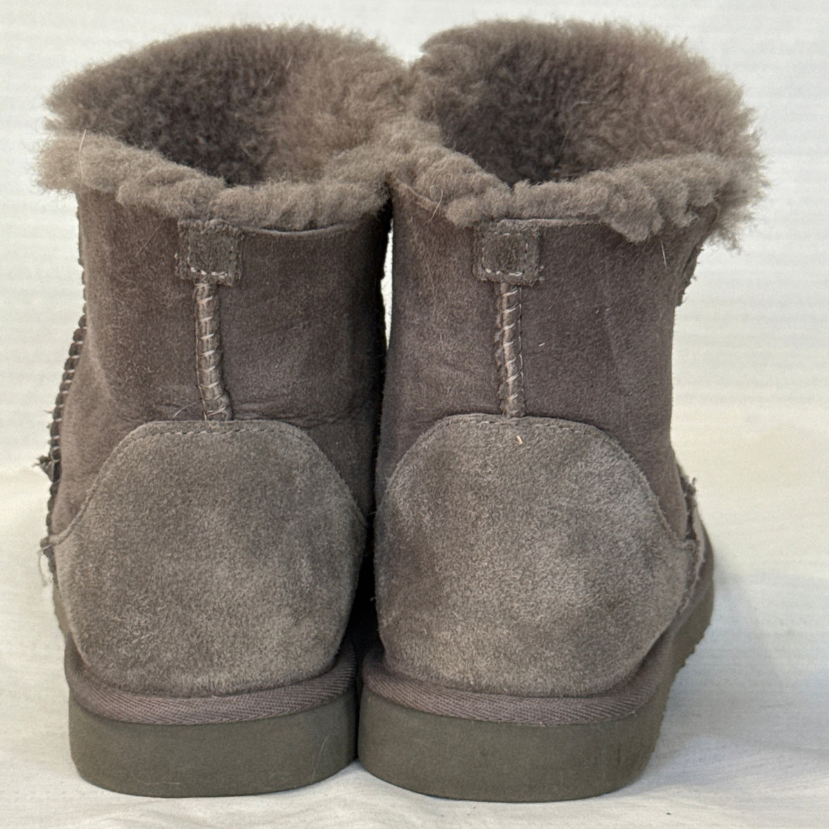 Back view of Member's Mark gray suede short boots showing heel panels, vertical stitching, and fluffy collars.