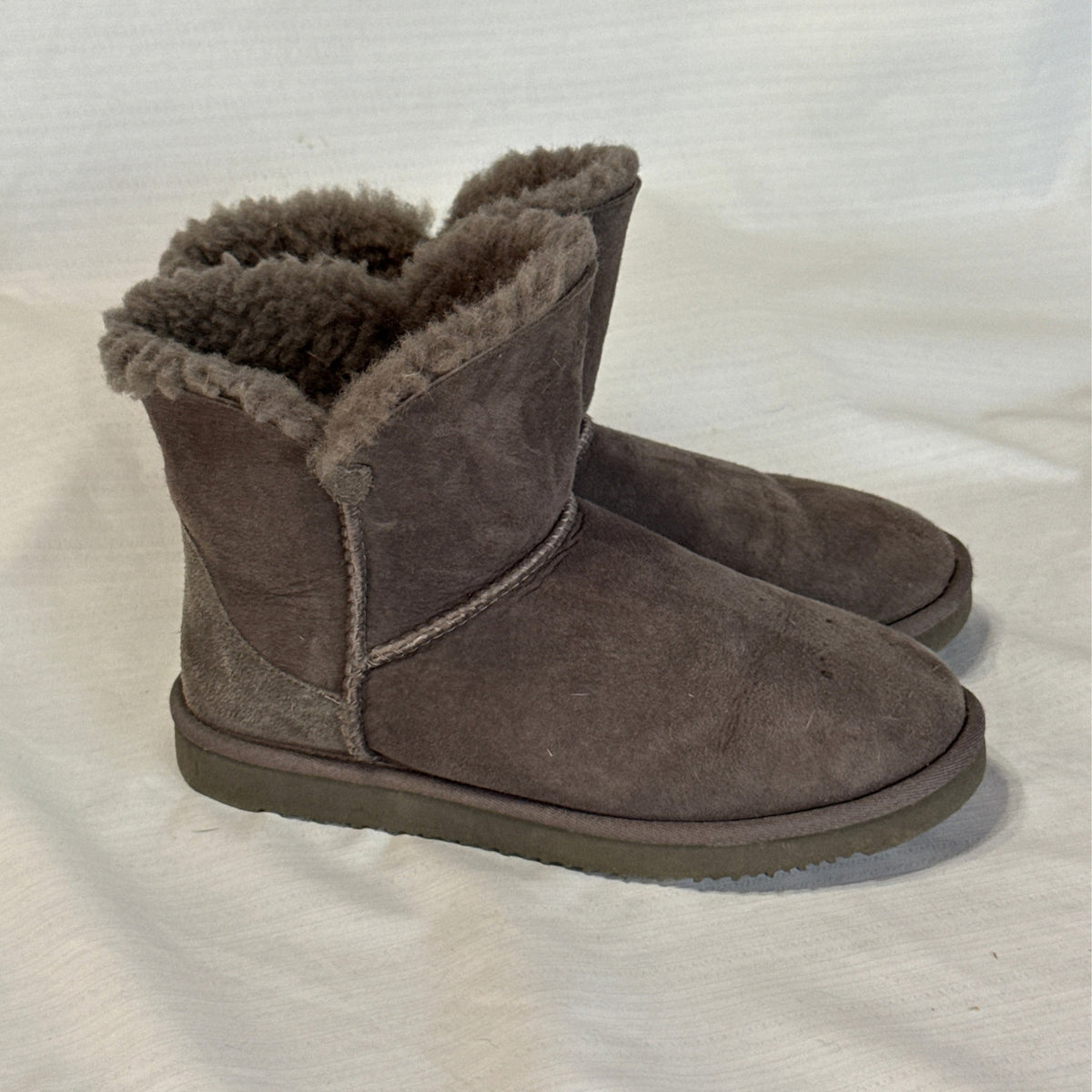 Side view of Member's Mark gray short boots showing suede uppers, stitched seams, and fuzzy sheepskin cuffs.