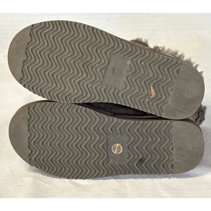 Bottom view of Member's Mark gray sheepskin short boots showing textured outsoles, visible tread wear, and a circular insert on one sole.