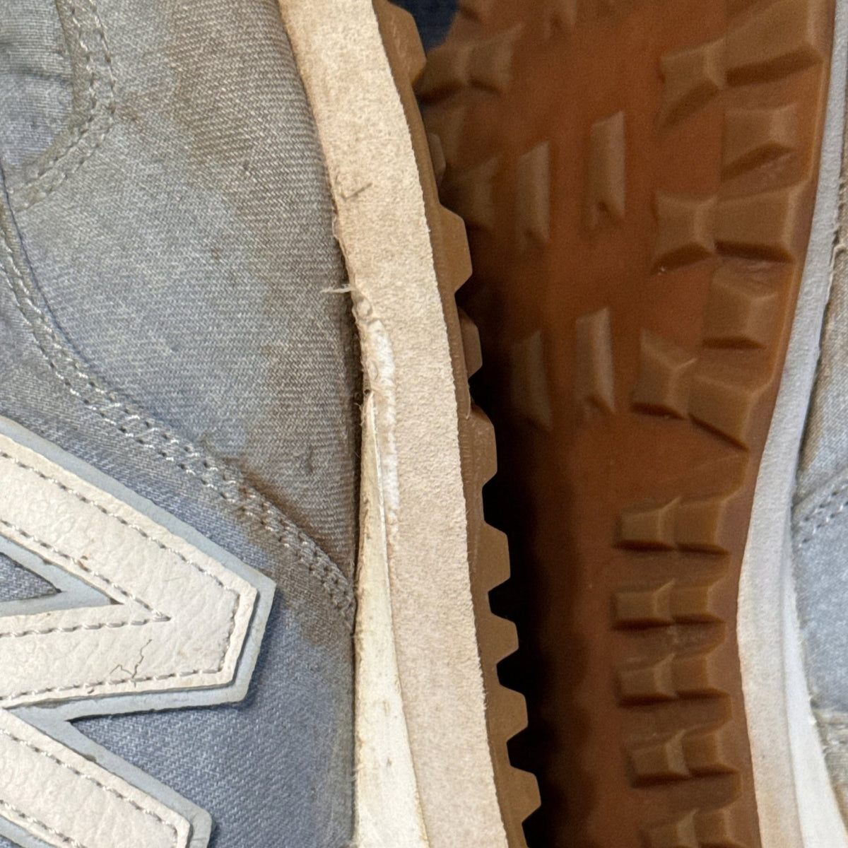 Close-up showing inner-side sole separation on the other New Balance sneaker.