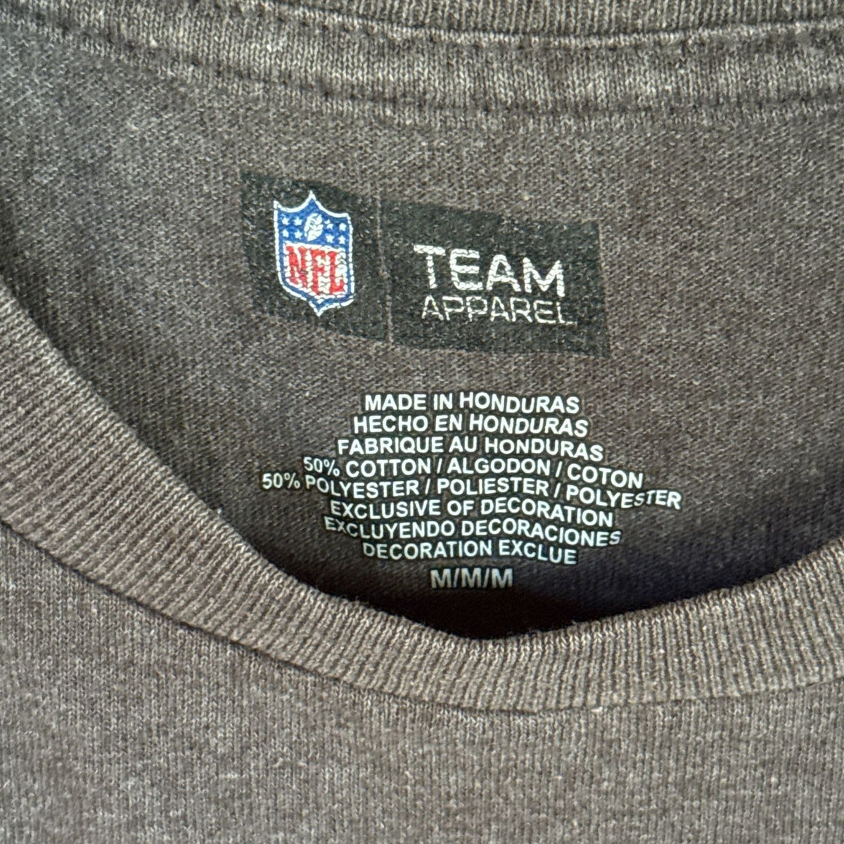 Front view of a charcoal gray New Orleans Saints T-shirt with a gold fleur-de-lis and faded Saints Football lettering.