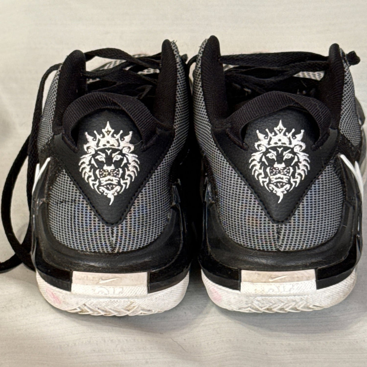 Back of Nike LeBron Witness 7 sneakers featuring white lion graphics and black and gray mesh.
