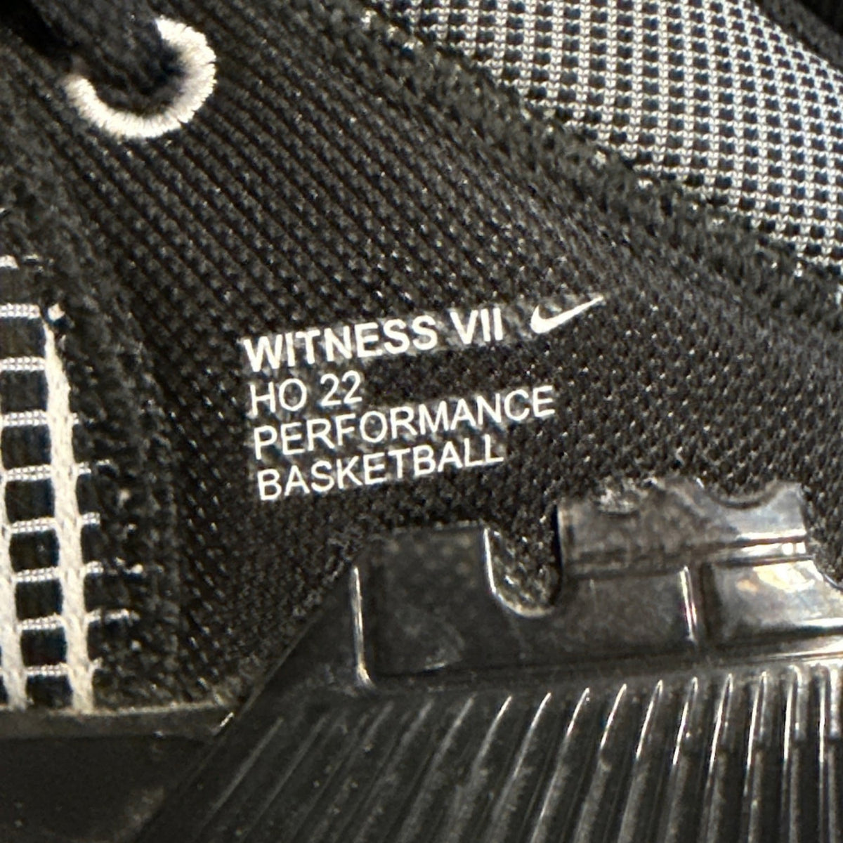 Close-up of Nike Witness VII performance basketball branding inside black shoe.