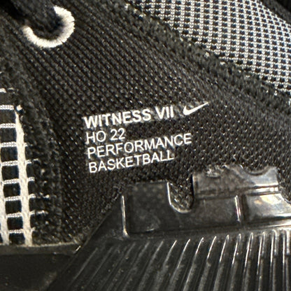 Close-up of Nike Witness VII performance basketball branding inside black shoe.