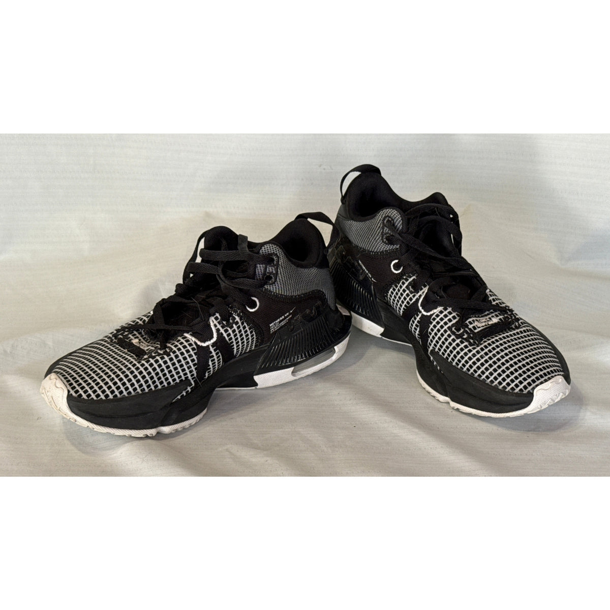 Pair of Nike LeBron Witness 7 black and white lace-up basketball shoes shown at an angle.