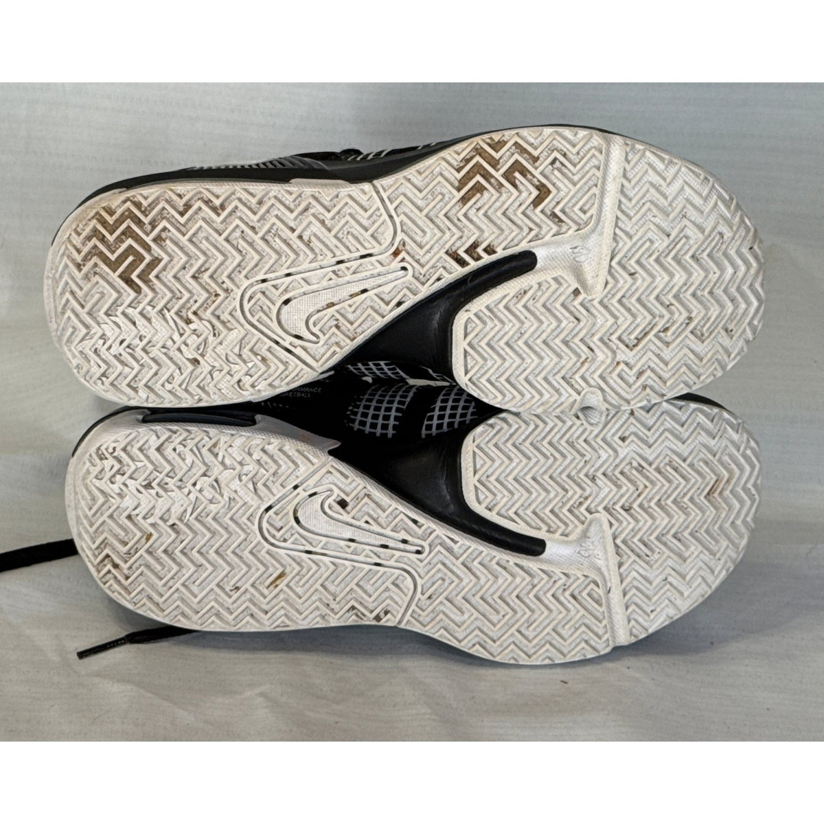 White rubber outsoles of Nike LeBron Witness 7 basketball shoes showing tread pattern and wear.