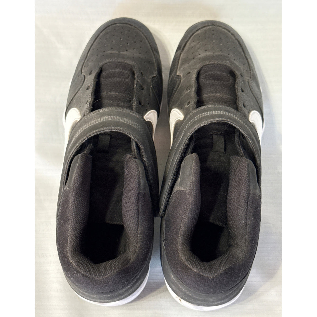 Top view of both Nike baseball cleats showing padded collars, fabric tongues, and empty lace holes.
