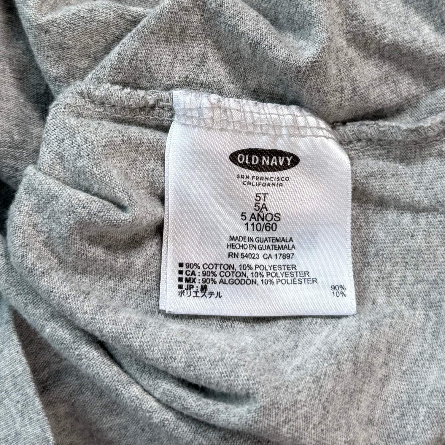 Old Navy boys size 5T shirt material and care tag showing 90 percent cotton and 10 percent polyester