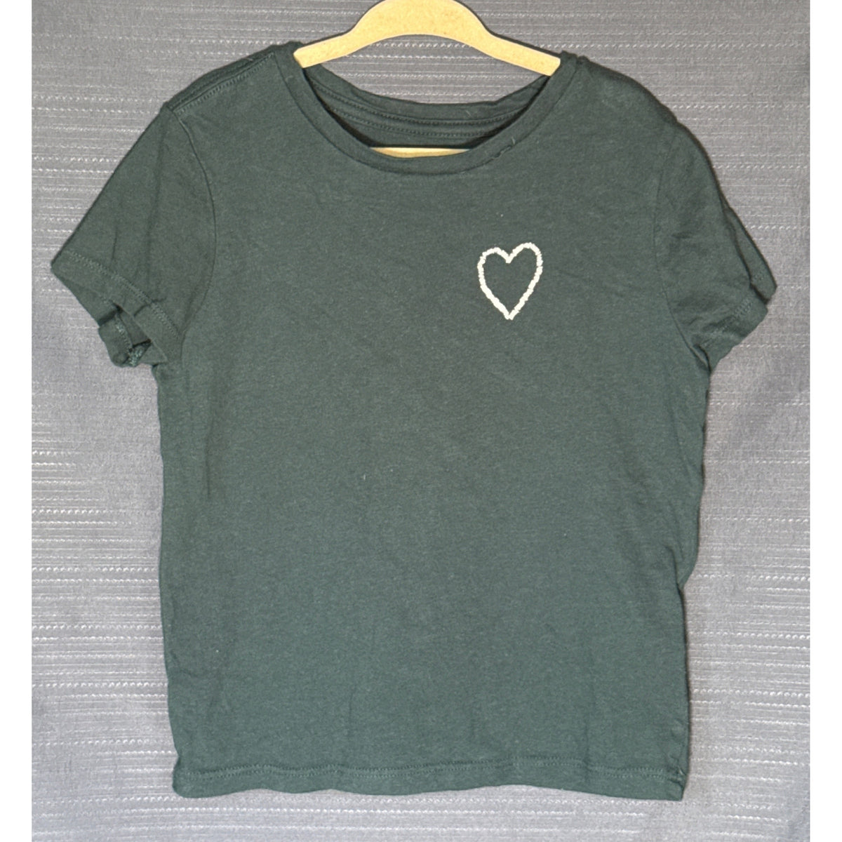 Front of Old Navy girls muted teal green short-sleeve T-shirt with small white outlined heart graphic on chest, size 6–7.