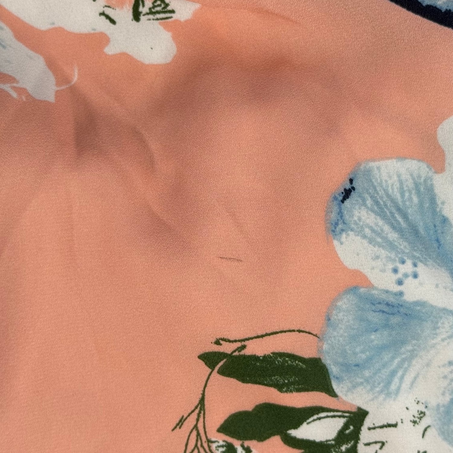Small snag and marks on peach floral dress fabric