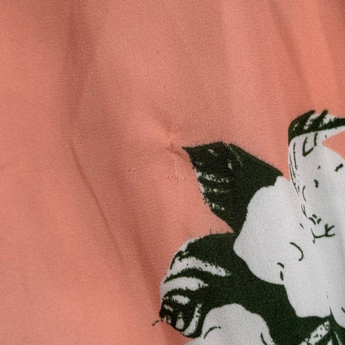 Small snag and marks on peach floral dress fabric