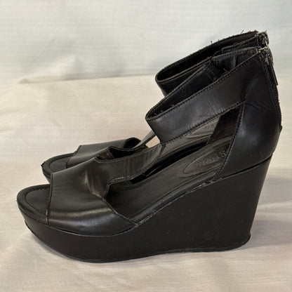 Side profile of black Reaction Kenneth Cole platform wedge sandals showing cutout sides and wedge heels.