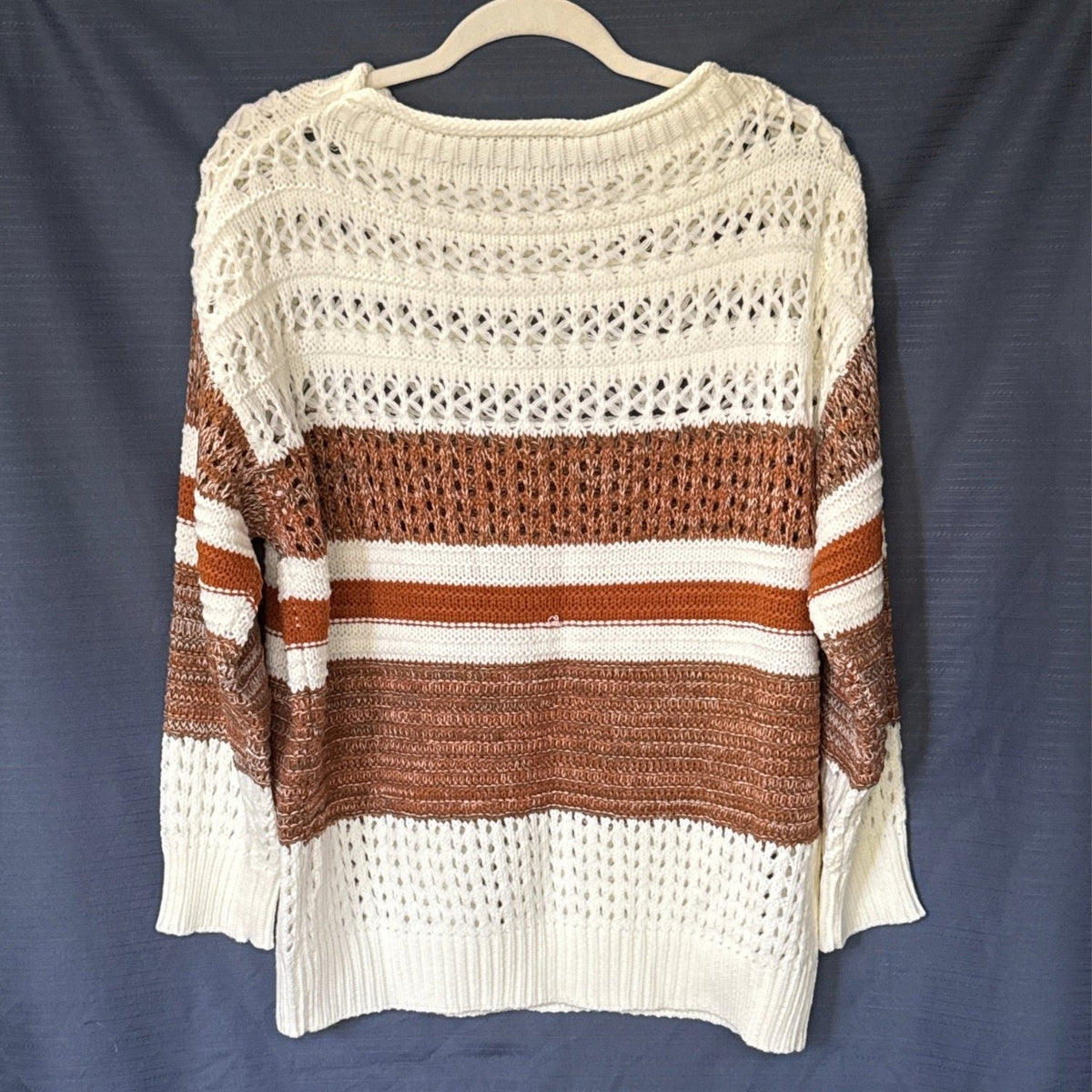 Back of a women’s SHEIN sweater with cream, brown, and burnt orange horizontal stripes, open-knit details, and long sleeves.