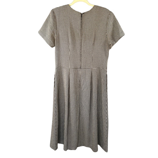 Back view of Stephanie Andrews black-and-white checkered midi dress with short sleeves, waist seam, pleated skirt, and center back zipper.