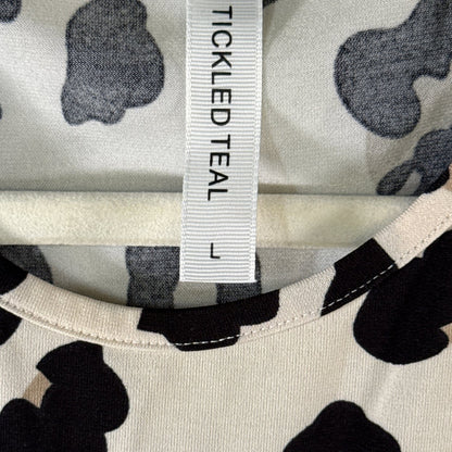 Close-up of Tickled Teal brand label showing size Large on cream and black leopard print fabric.