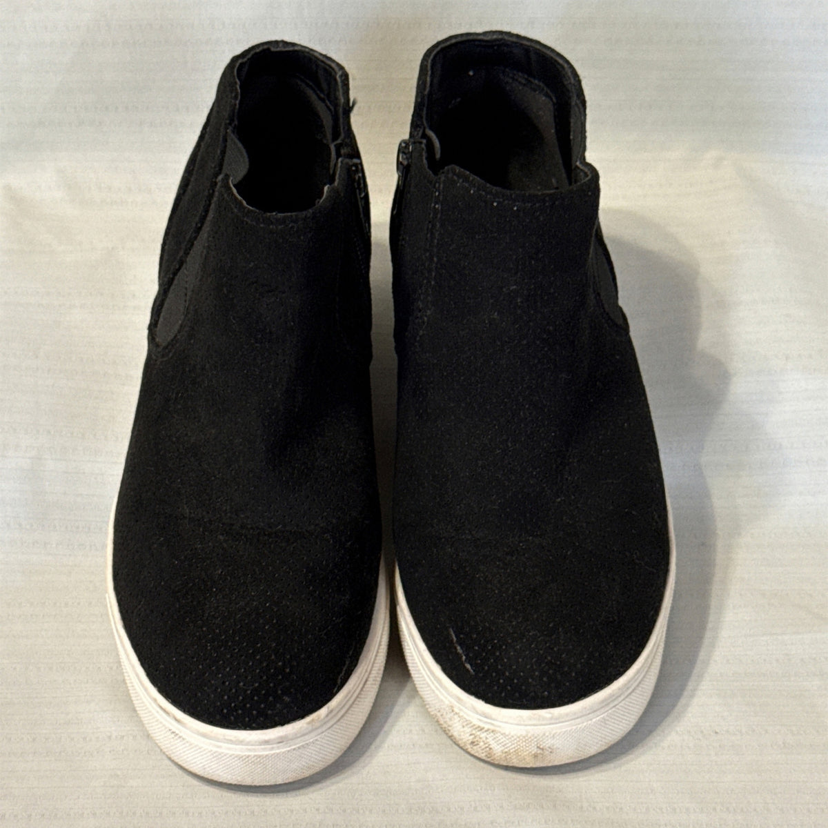Front view of black Time and Tru sneaker booties showing rounded perforated toes, elastic side panels, and white soles.