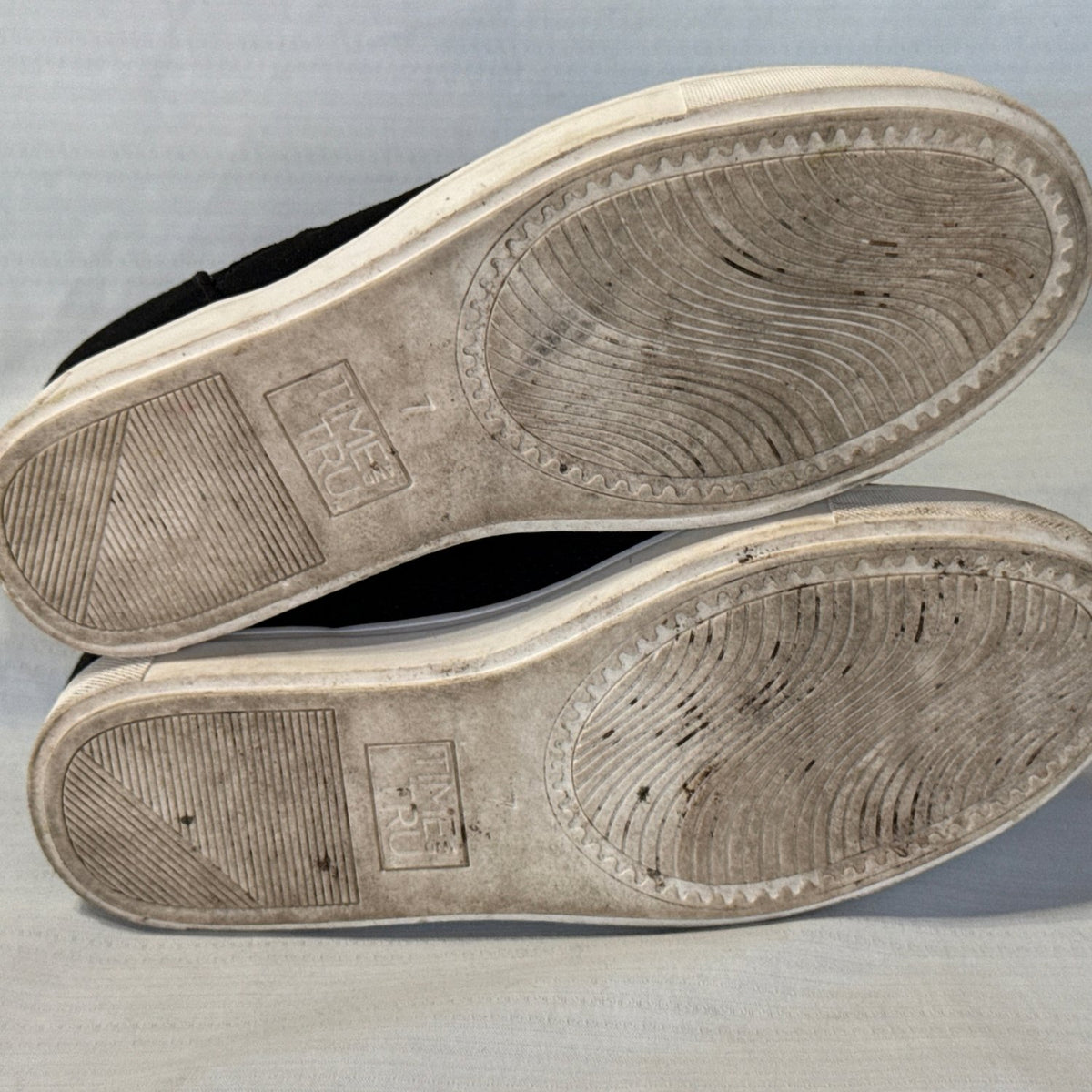 Bottom view of Time and Tru sneaker booties showing size 7 markings, textured tread, and visible sole wear.
