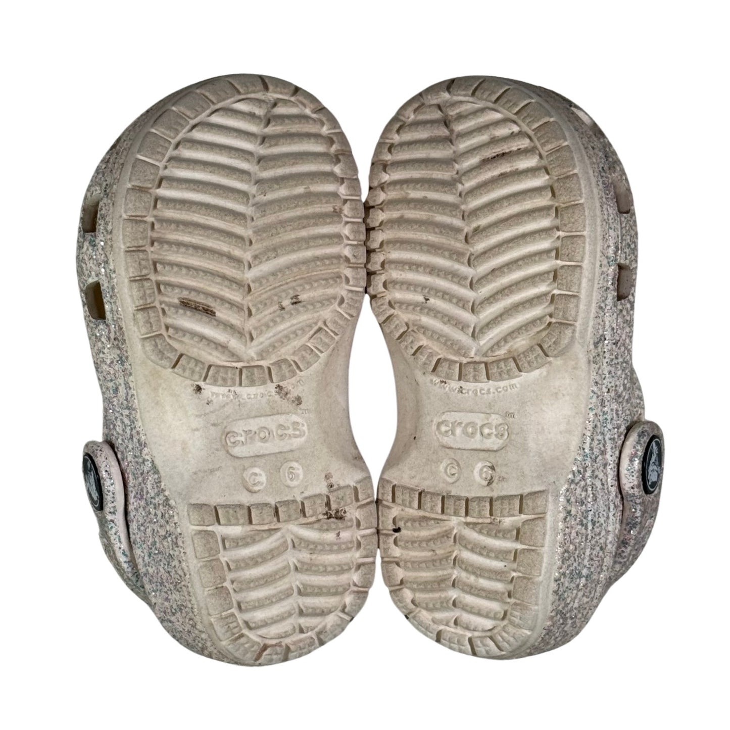 Close-up of a pair of Crocs shoes with textured soles on a white background
