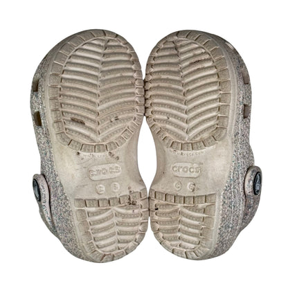 Close-up of a pair of Crocs shoes with textured soles on a white background