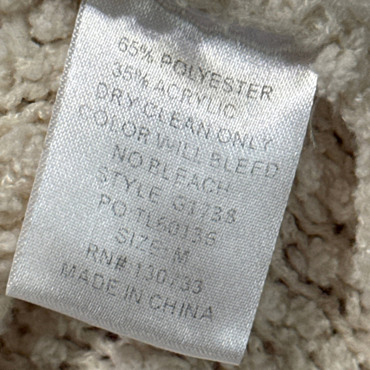 Umgee cardigan fabric label showing 65% polyester and 35% acrylic.