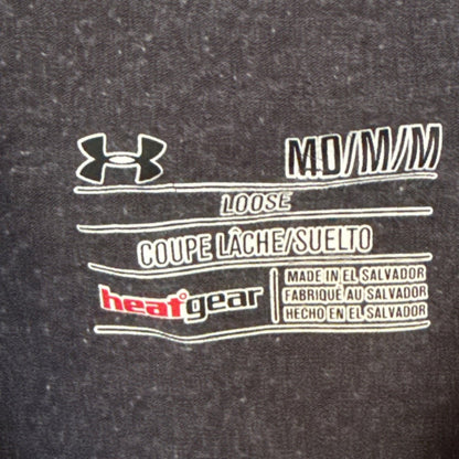 Under Armour printed neckline label showing Medium, Loose fit, HeatGear, and made in El Salvador