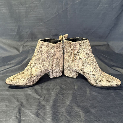 Inner side view of both Very G snake-print ankle boots showing zipper closures and block heels.
