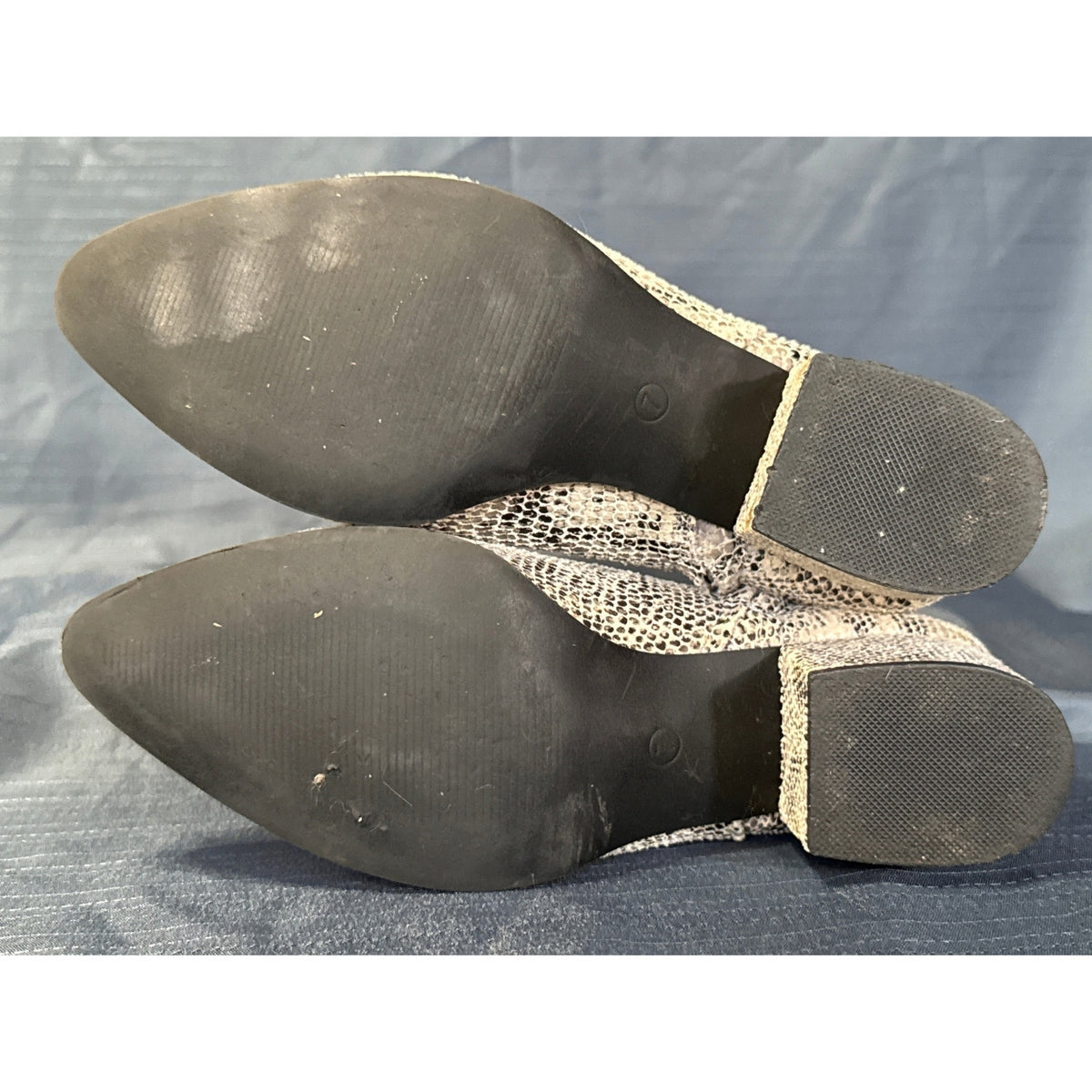 Bottom view of Very G women’s size 7 ankle boots showing black soles with light wear.