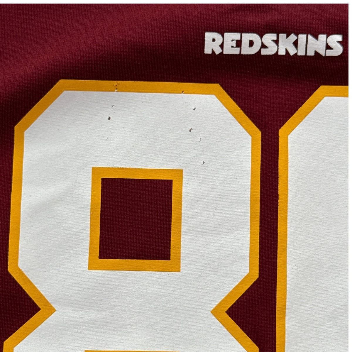 Close-up of small snags on front number 8 of Jordan Reed youth NFL jersey