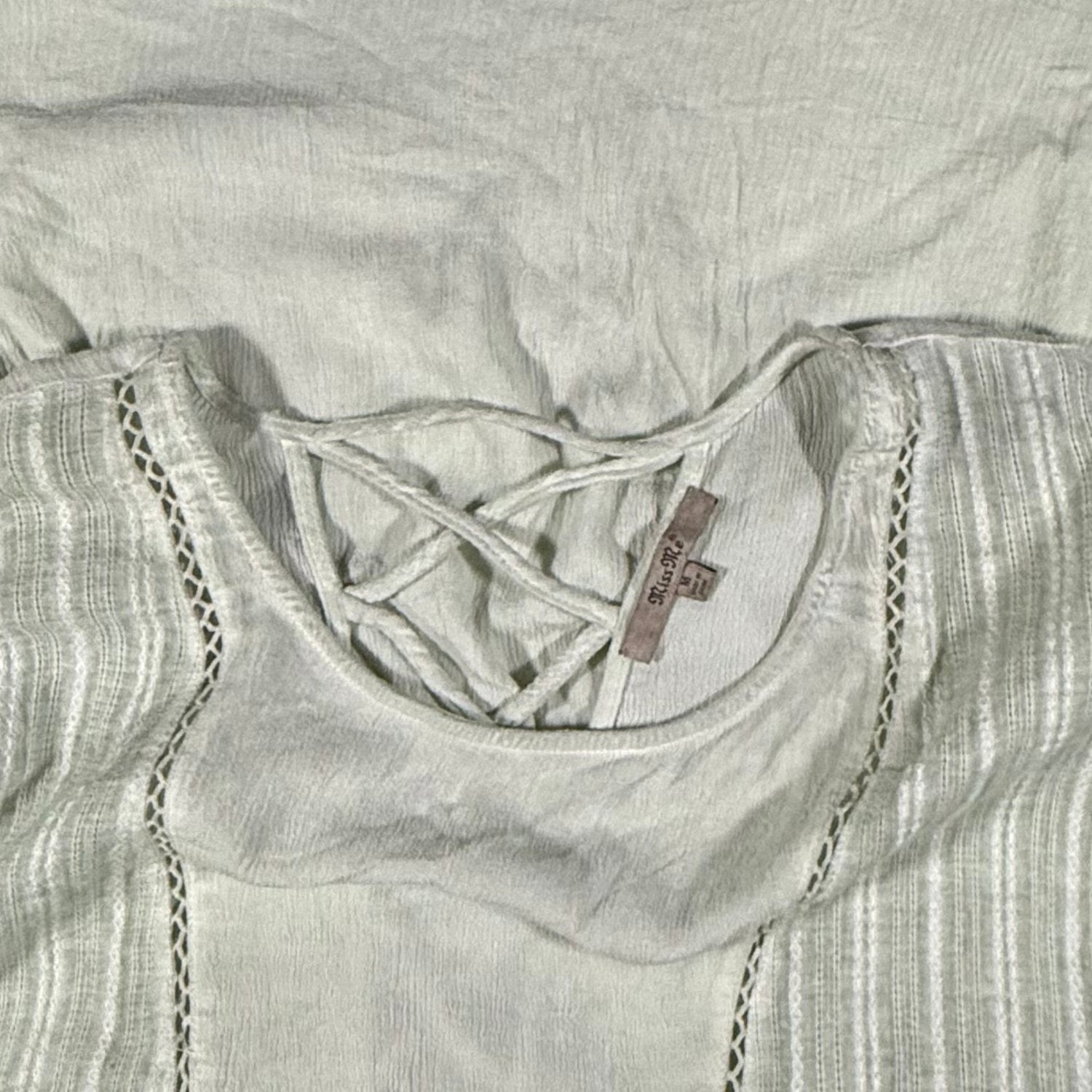 Miss Me brand tag on a women's medium light sage green blouse.