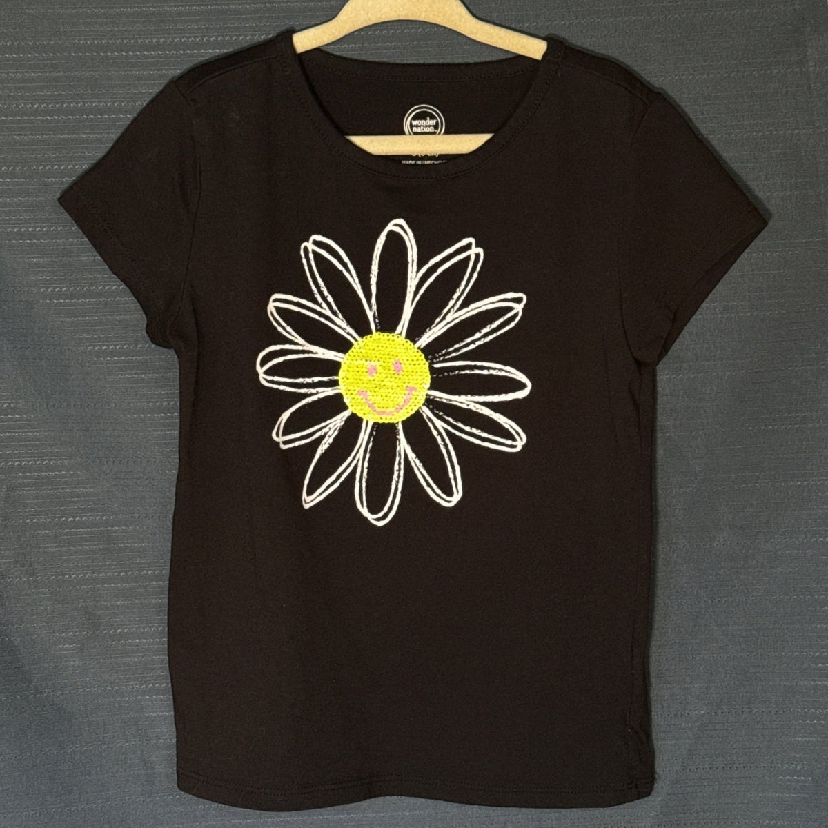 Wonder Nation girls black T-shirt with large white daisy graphic and yellow sequin smiley face center, size 6–6X.