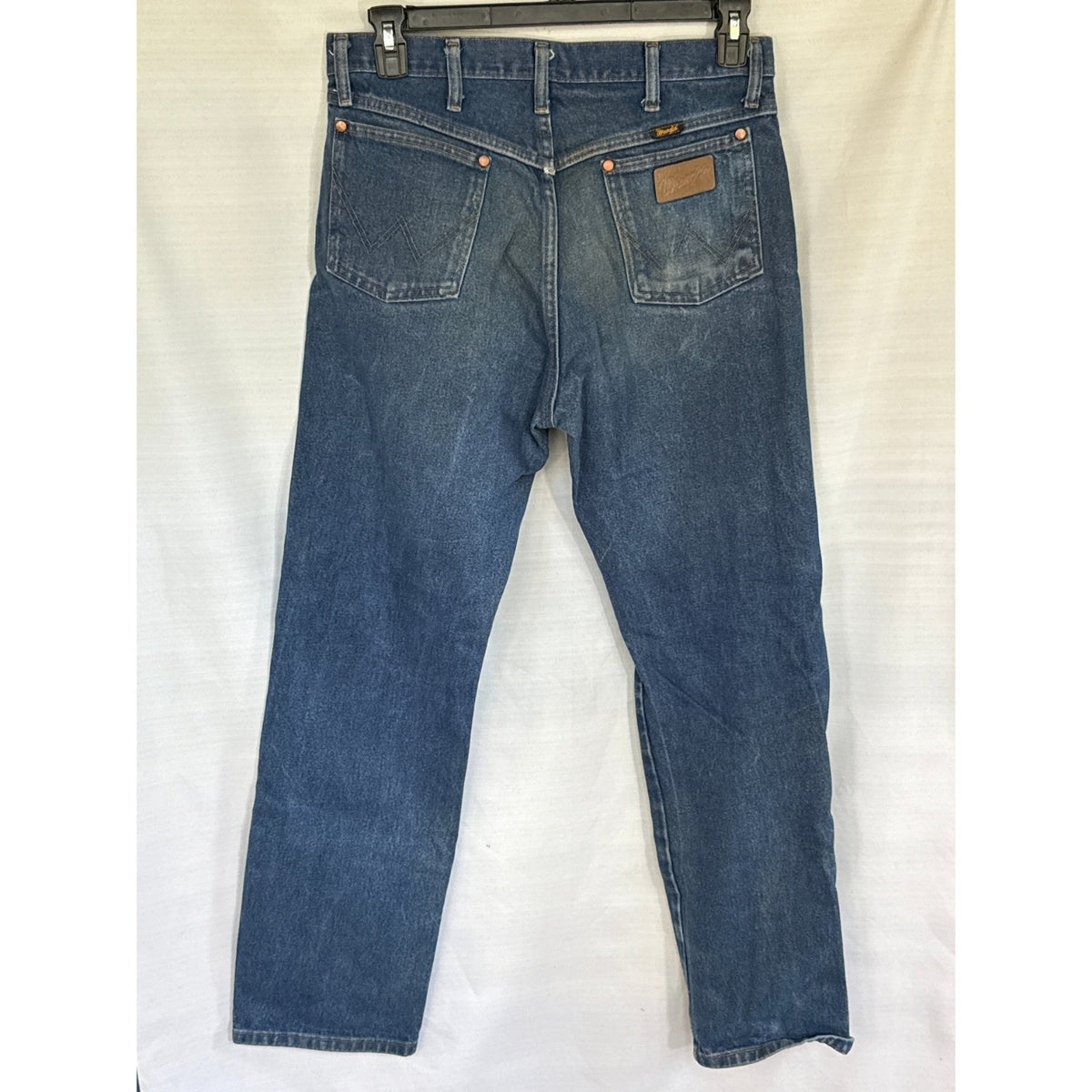 Back of Wrangler 13MWZ men’s blue jeans with signature W-stitched pockets, Wrangler patch, and natural fading