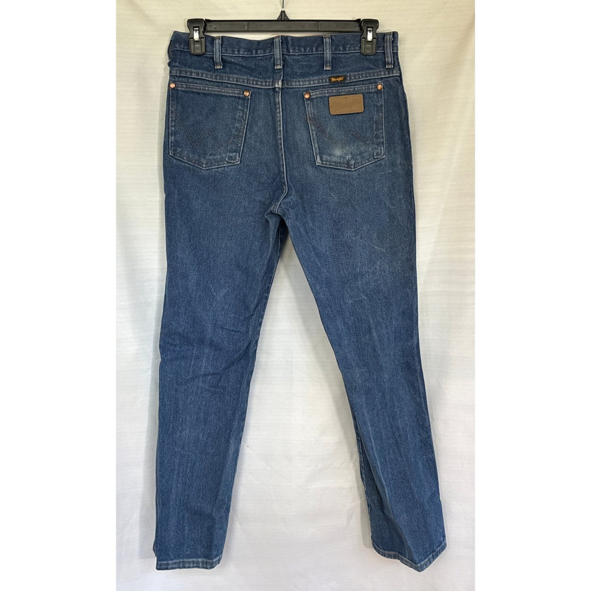 Back view of blue Wrangler men’s jeans with W-stitched pockets and wear on the right pocket