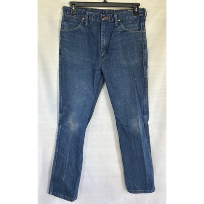 Front view of blue Wrangler men’s jeans with fading, stains, and a button waist closure