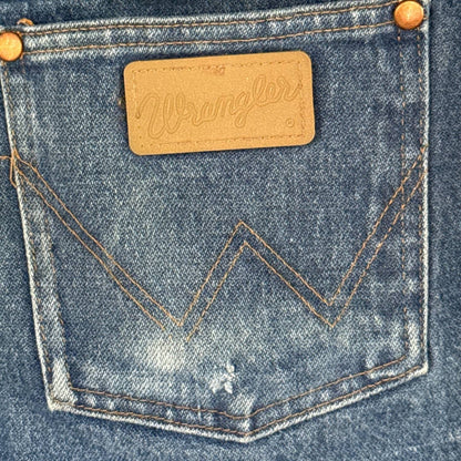 Close-up of the small hole near the bottom of the right back pocket on blue Wrangler jeans